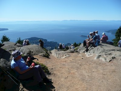 Hikers sat atop mountain enjoying expansive view, Canada