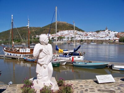 White Smuggler statue with boats and white houses at Alcoutim