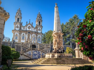 Nossa Senhora dos Remédios Sanctuary in Lamego, Portugal, with the church in the background and fountain with obelisk in the foreground, on a blue sky day