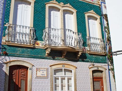 Blue and grey tiled house with woman walking past, Tavira, Algarve, Portugal